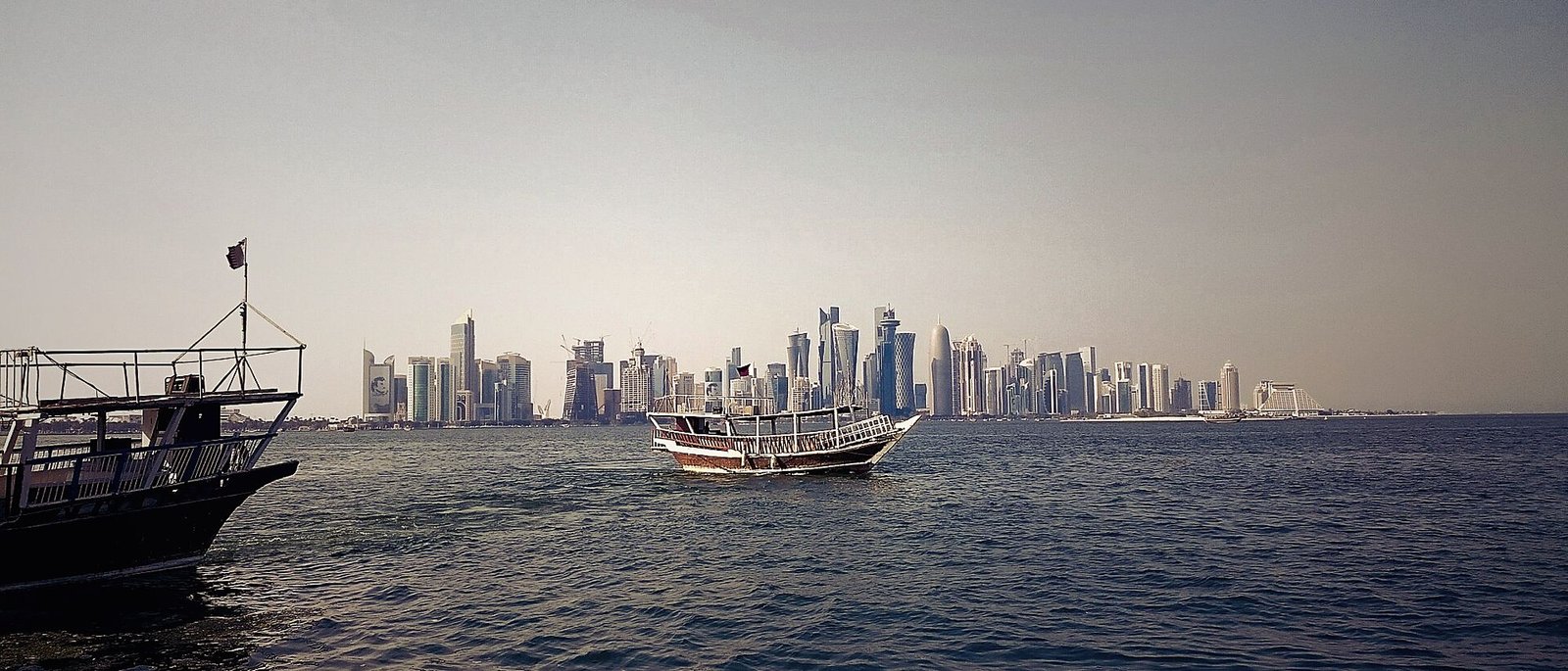 Traditional dhow boats moored along the Doha Corniche